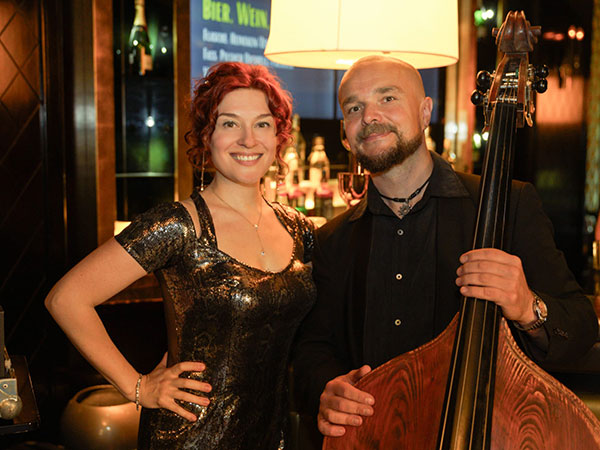 Solo-Pianistin Yuliya Drogalova steht vor einem schwarzen Flügel, neben ihr steht der Kontrabassist Bartek Mlejnek
